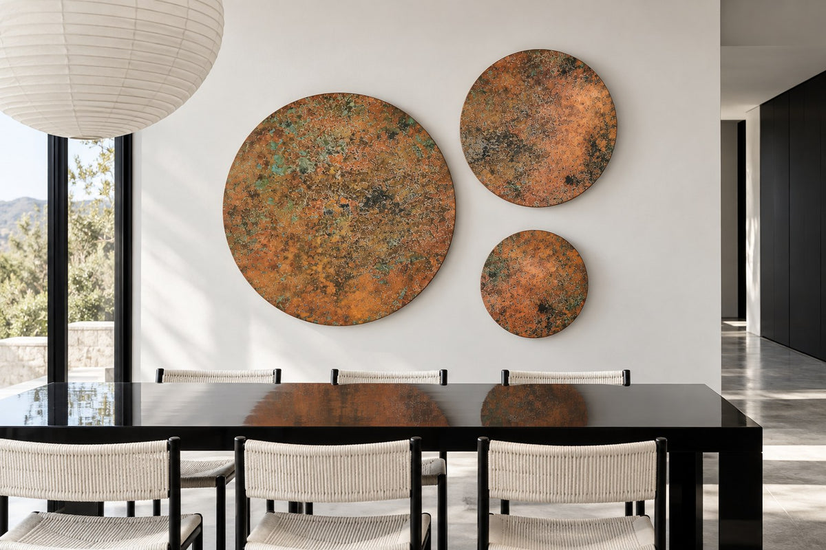 Copper Orbit Mystic Copper Nebula – set of 3 copper circles on a white wall above a black dining table with woven chairs, room visualization